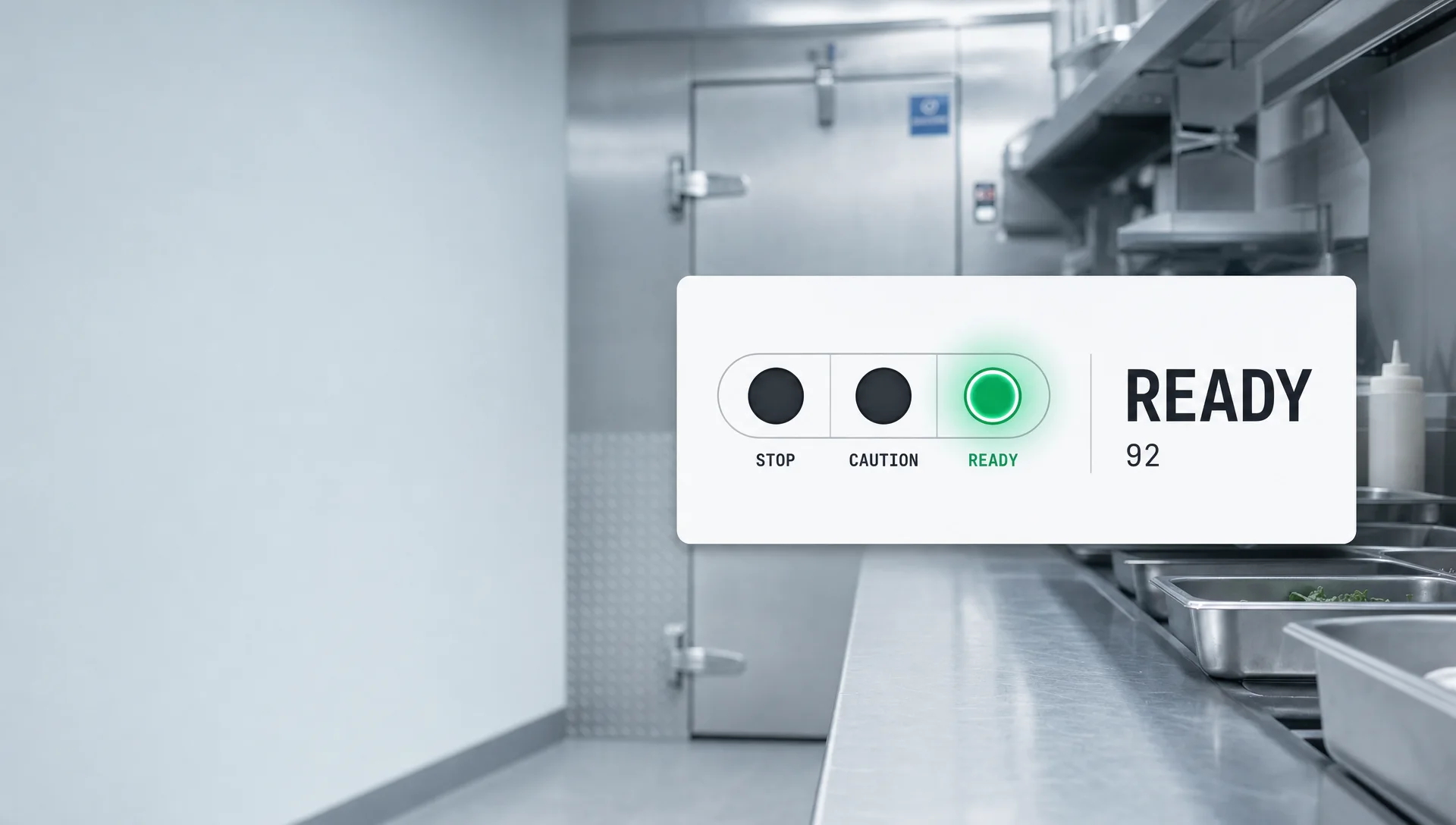 A job-readiness meter card reading READY 92, only the green lamp lit, over a cool blurred stainless commercial-kitchen prep line